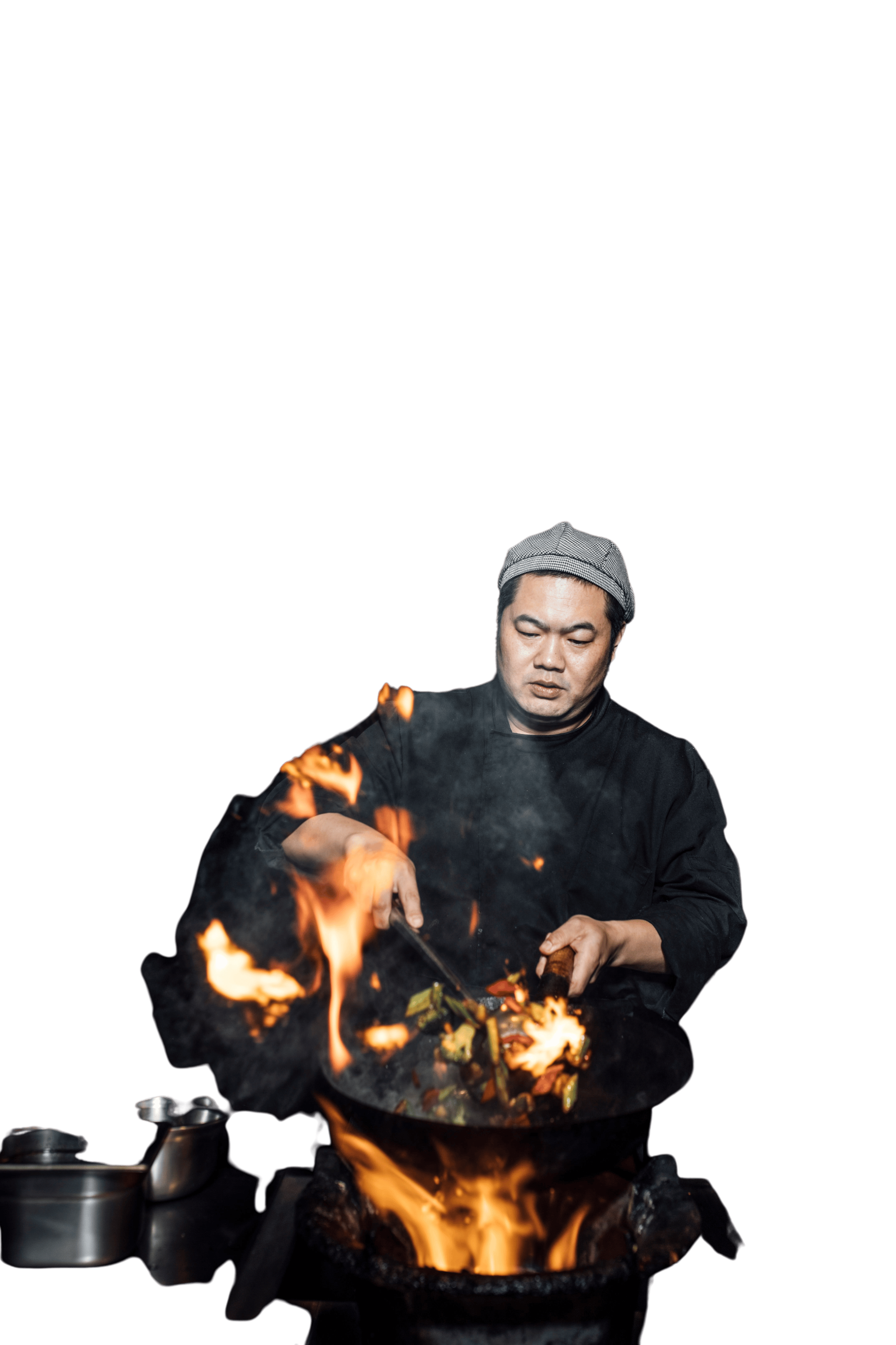 Skilled male chef lights the wok on fire.